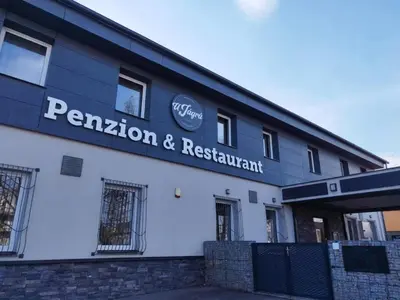 a building with a sign for a restaurant and restaurant at Penzion a restaurace U Jágrů in Kladno