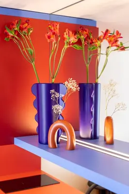 two blue vases with flowers on a shelf at TurnKey I Vinohrady Modern Apartments in Prague