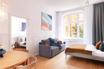 a living room with a bed and a dining room table at TurnKey I Vinohrady Modern Apartments in Prague