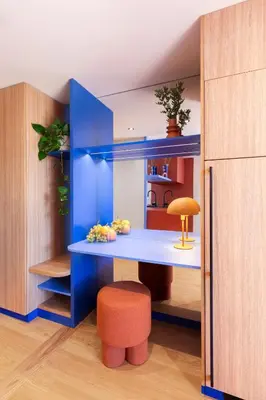 a room with a blue desk with a stool and a table at TurnKey I Vinohrady Modern Apartments in Prague