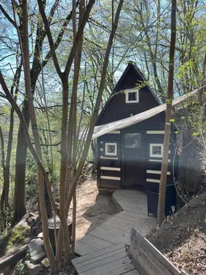 a small black house in the middle of the woods at Králíkova chatka in Kaliště
