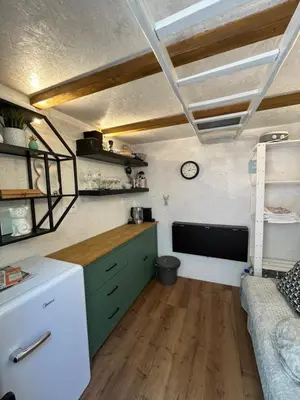 a kitchen with green cabinets and a couch in a room at Králíkova chatka in Kaliště