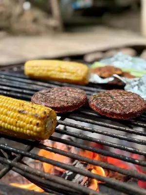 a grill with corn and hamburgers and hamburgers and corn on at Králíkova chatka in Kaliště