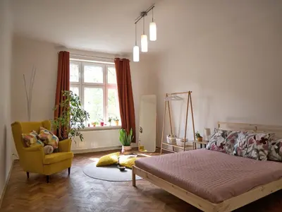 a bedroom with a bed and a chair and a window at Quiet and spacious flat near city centre in Prague 3 in Prague