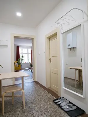a living room with a table and a mirror at Quiet and spacious flat near city centre in Prague 3 in Prague