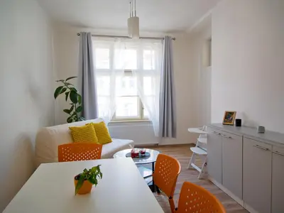 a living room with a table and orange chairs at Quiet and spacious flat near city centre in Prague 3 in Prague