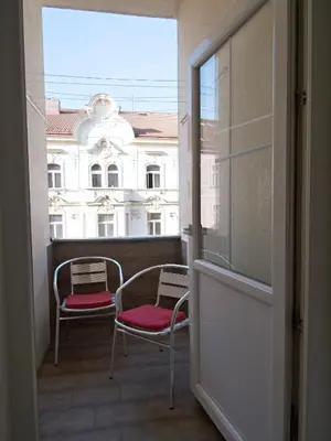 a balcony with two chairs and a view of a building at Quiet and spacious flat near city centre in Prague 3 in Prague