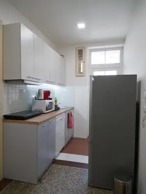 a kitchen with white cabinets and a refrigerator at Quiet and spacious flat near city centre in Prague 3 in Prague