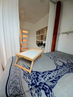 a wooden table sitting on top of a bed at Apartment Dreamy Valley in Nenačovice