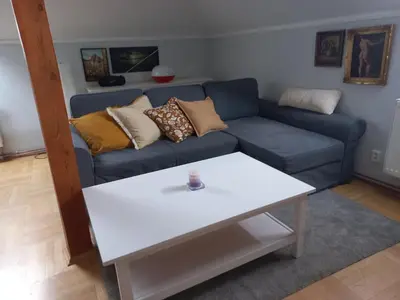 a living room with a blue couch and a white table at Apartment Dreamy Valley in Nenačovice