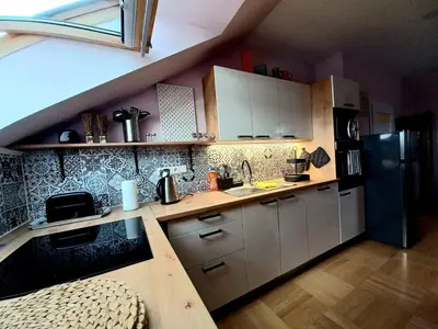 a kitchen with white cabinets and a black refrigerator at Apartment Dreamy Valley in Nenačovice