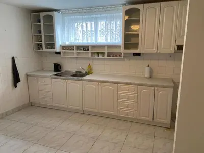 a kitchen with white cabinets and a sink at Apartment in a family home in Chocerady