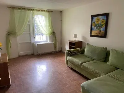 a living room with a couch and a window at Apartment in a family home in Chocerady