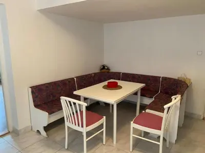 a table and a couch with a table and chairs at Apartment in a family home in Chocerady