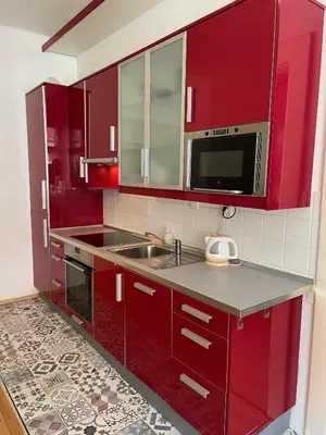 a red kitchen with a sink and a microwave at Apartment Flora Lobkovic in Prague