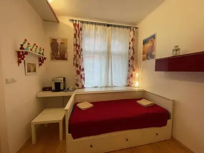 a small room with a bed and a window at Apartment Flora Lobkovic in Prague