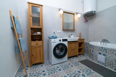 a bathroom with a washing machine and a sink at Prague Vinohrady Apartment in Prague