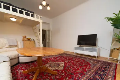 a living room with a table and a tv at Prague Vinohrady Apartment in Prague