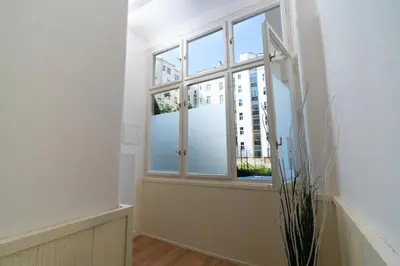 an empty room with a window and a plant at Prague Vinohrady Apartment in Prague