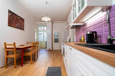 a kitchen with a table and a purple wall at Prague Vinohrady Apartment in Prague