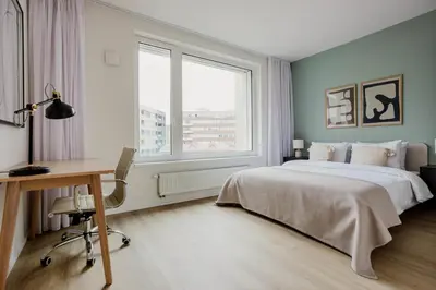 a bedroom with a bed and a desk and a window at Blueground Holešovice museums foodie area PRG-11 in Prague