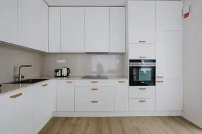 a white kitchen with white cabinets and a sink at Blueground Holešovice museums foodie area PRG-11 in Prague