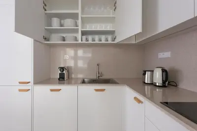 a white kitchen with white cabinets and a sink at Blueground Holešovice museums foodie area PRG-11 in Prague