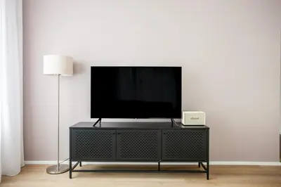 a flat screen tv on top of a black entertainment center at Blueground Holešovice museums foodie area PRG-11 in Prague