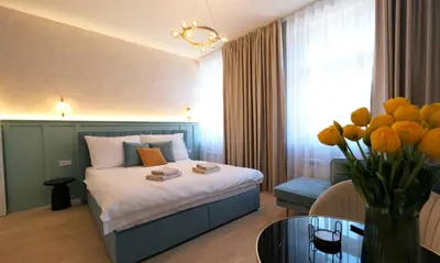 a hotel room with a bed and a vase of flowers at Luxemi Apartments I Wenceslas Square in Prague