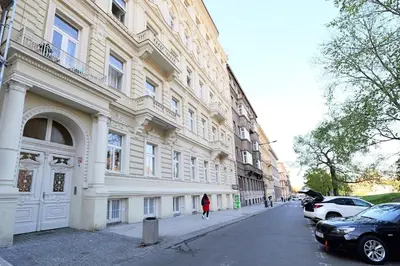 a woman walking down a street in front of a building at Luxemi Apartments I Wenceslas Square in Prague