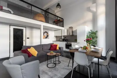 a living room and kitchen with a couch and a table at Family duplex apartment near center in Prague