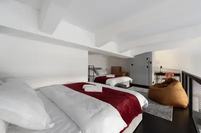 a bedroom with two beds with white sheets and red blanket at Family duplex apartment near center in Prague