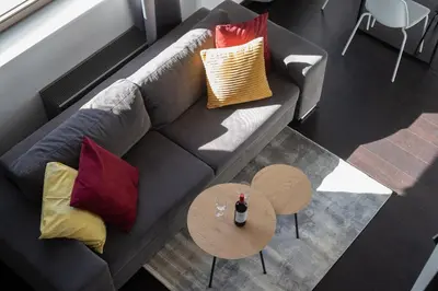 a gray couch with colorful pillows and a table at Family duplex apartment near center in Prague