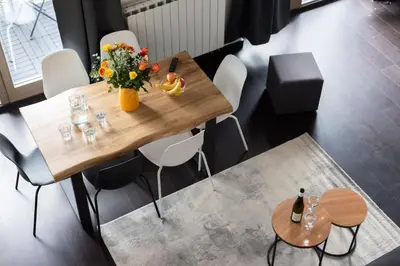 a wooden table with a vase of flowers on it at Family duplex apartment near center in Prague