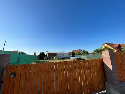 a fence in front of a house with a trailer behind it at Mobilheim Natálka in Račice