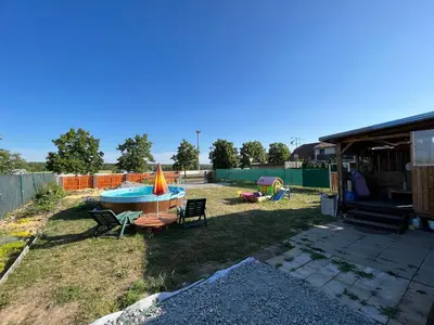 a backyard with a pool with a table and chairs at Mobilheim Natálka in Račice