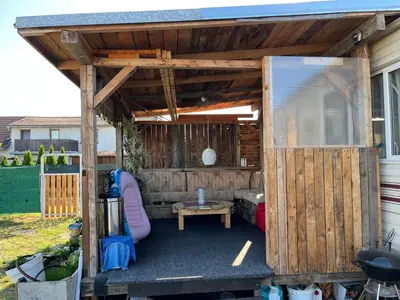 a backyard pergola with a bed and a table at Mobilheim Natálka in Račice