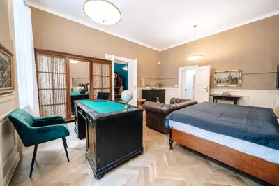 a bedroom with a bed and a desk and a couch at WagnerStays Grand Nest 6BD Billiard&Sauna&Cinema in Prague