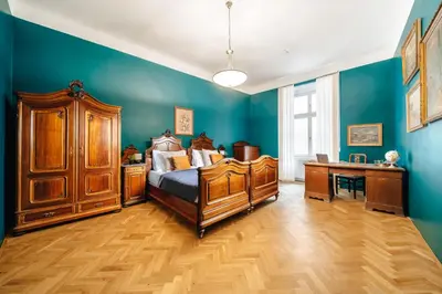 a bedroom with blue walls and a bed and a desk at WagnerStays Grand Nest 6BD Billiard&Sauna&Cinema in Prague