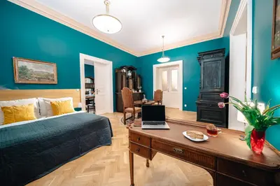 a bedroom with a bed and a desk with a laptop at WagnerStays Grand Nest 6BD Billiard&Sauna&Cinema in Prague