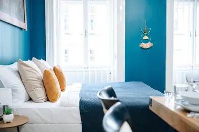 a bedroom with a bed with a blue wall at WagnerStays Grand Nest 6BD Billiard&Sauna&Cinema in Prague