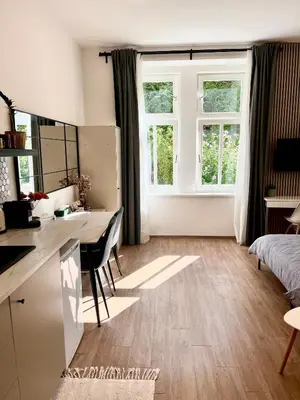 a living room with a desk and a bedroom at Bright and cozy studio 15 minutes to city center in Prague