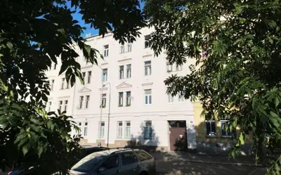 a white building with a car parked in front of it at Bright and cozy studio 15 minutes to city center in Prague