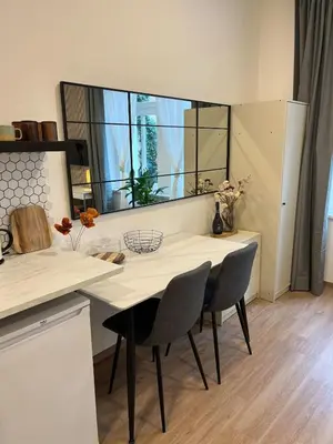 a kitchen with a table and chairs and a window at Bright and cozy studio 15 minutes to city center in Prague