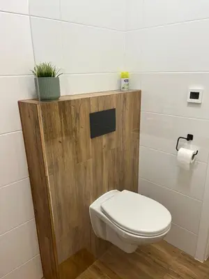 a bathroom with a toilet and a plant on a shelf at Bright and cozy studio 15 minutes to city center in Prague