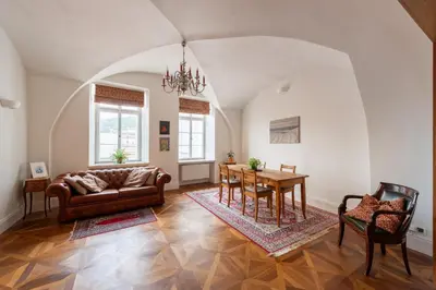 a living room with a table and a couch at Stay Beneath Prague Castle Where Mozart Performed in Prague