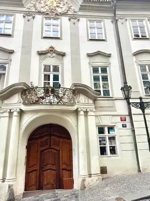 a building with a large wooden door and a balcony at Stay Beneath Prague Castle Where Mozart Performed in Prague