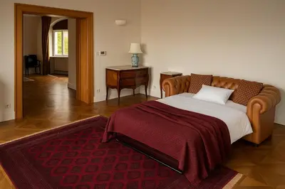 a bedroom with a large bed with a red blanket at Stay Beneath Prague Castle Where Mozart Performed in Prague