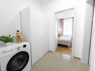 a washing machine in a white room with a bedroom at Cozy nest - Perfect for Two in Prague
