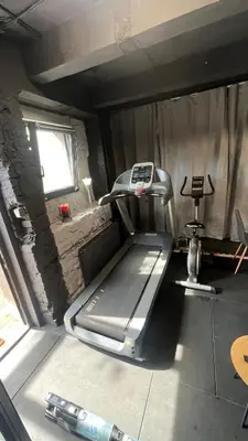 a gym room with a treadmill and a window at Apartment Sport & Sauna Prague in Prague